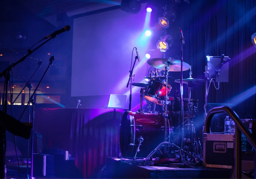 Dimly lit stage with musical instruments ready for performance.